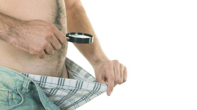 un home mira para os seus calzóns e pensa na ampliación do pene con refresco